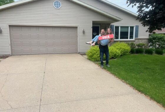 Man holding woman outside of house